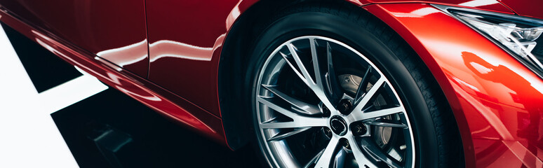 panoramic shot of new shiny red automobile with metallic wheel