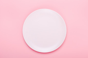 Pink plate on a pink background. Minimal composition. Copy space, top view, flat lay.