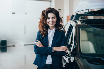 beautiful businesswoman standing with crossed arms and looking at camera