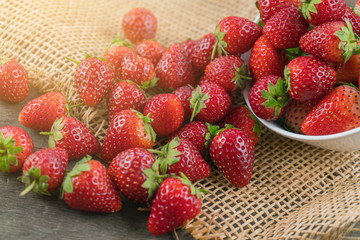 Stack of strawberries on sack cloth.