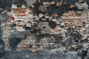 Black old destroyed plaster on a stone wall for backgrounds
