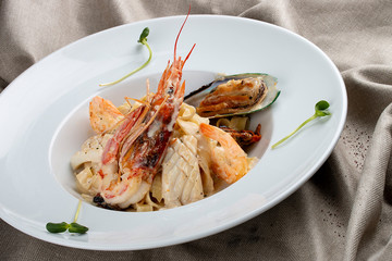 Tagliatelle with seafood on textile background