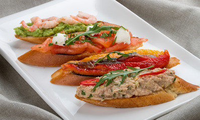 Brushetta snacks for wine. Variety of small sandwiches on a textile background