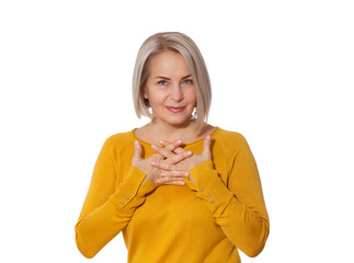 Middle aged blonde emotionally posing in a studio. Happy woman in yellow bright sweater on white background