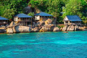 Fototapeta na wymiar Wooden tropical home on stilts over azure water of the Gulf of Thailand.