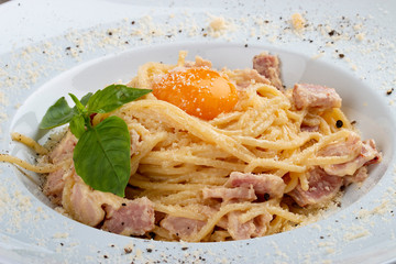 Spaghetti Carbonara on white plate on textile background