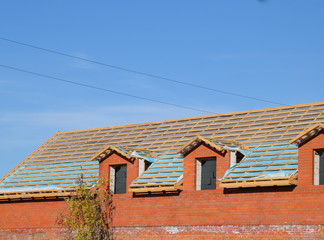 Construction of the roof of a new house. Wooden bars and vapor barrier