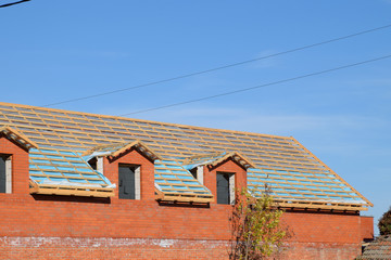 Construction of the roof of a new house. Wooden bars and vapor barrier