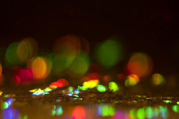 Blurred multicolor bokeh circles on dark background. Defocused lens flare glow. Abstract design.