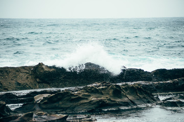 The waves were breaking on the rocks