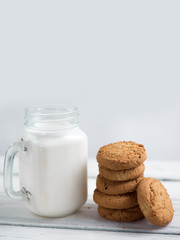 Milk and cookies on a wooden white table