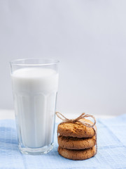 Glass of milk and cookies on wooden white background