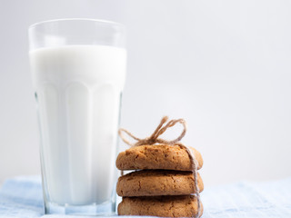 Glass of milk and cookies on wooden white background