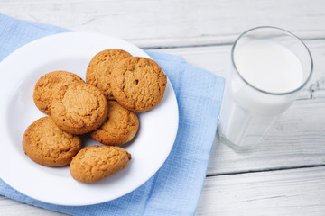 Glass of milk and cookies on wooden white background