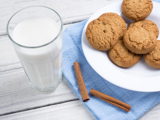 Glass of milk and cookies on wooden white background