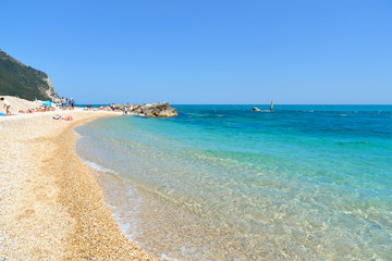 Sirolo (AN), Italy Detail of Urbani beach under rock cliff with people, Riviera del Conero,...