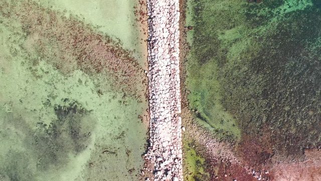 Aerial view of a stone breakwater at Marineta Beach, in Denia, Spain