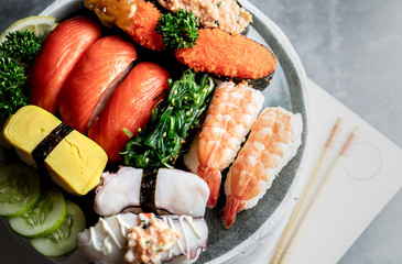 Japanese restaurant, sushi set on black slate plate top view, food concept background.