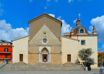 Fototapeta premium Detail of Orbetello Cathedral, Concattedrale di Santa Maria Assunta and city scape and buildings with blue cloudy sky in summer day, Grosseto Tuscany Italy