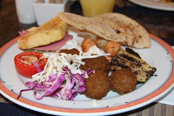 Portion of fresh vegetables cabbage, cutlets and stuffed tomato at restaurant