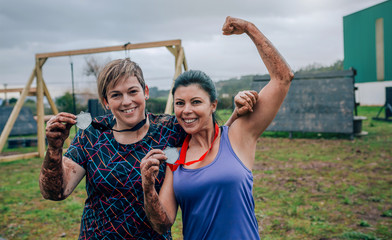 Two female athletes showing their medals after a race
