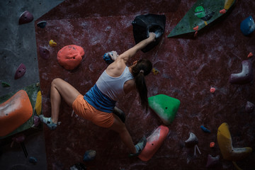Athletic woman practicing in a bouldering gym