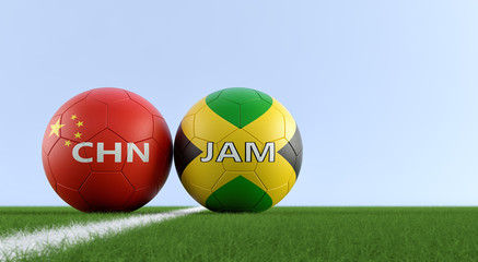 Jamaica vs.China Soccer Match - Soccer balls in Jamaicas and Chinas national colors on a soccer field. Copy space on the right side - 3D Rendering 