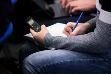 a voice recorder in the hand of a journalist