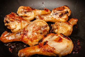Roasted chicken legs on the black background. Top view.