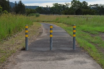 Fototapeta na wymiar Three steel posts marking the end of a road landscape