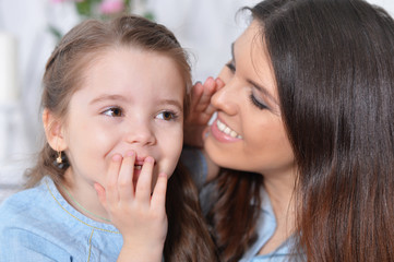 Close up portrait of little girl with mother hugging 