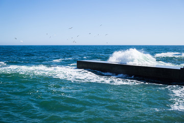 Sea waves on the beach, bright blue water