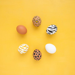 Dyed Easter eggs on yellow background. Creative animal pattern.