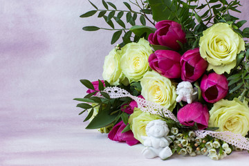 on a pink background, a bouquet of white roses and pink tulips and two white angels