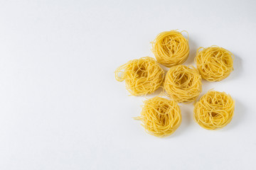 on a white background pasta in the form of nests