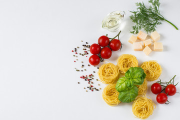 on a white background pasta in the form of nests, tomatoes, peppers, basil, olive oil, dill, cheese 