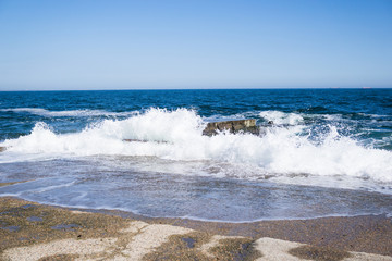 Sea waves on the beach, bright blue water