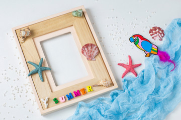on a white background photo frame, starfish, shells, the word sea, sand and a ship. Background about summer vacation, memories