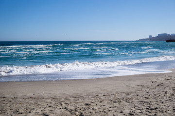 Sea waves on the beach, bright blue water