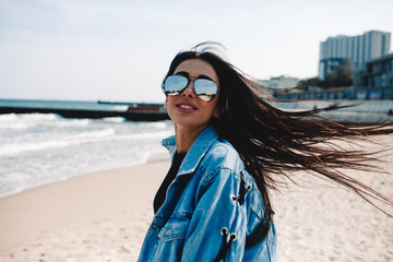 Great pleasure. Charming calm young woman is standing near sea with closed eyes and expressing...