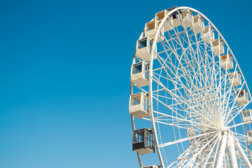 Big city ferris wheel on a background of clean blue sky