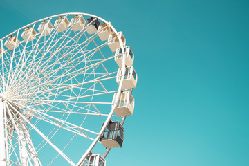 Big city ferris wheel on a background of clean blue sky - obrazy, fototapety, plakaty