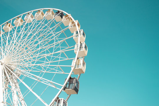 Big city ferris wheel on a background of clean blue sky