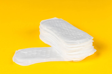 Daily panty liners on yellow background close-up. Discrete panty liner or pad for woman. Intimate hygiene. Woman hygiene protection. Women's health. Feminine pads. Critical days.