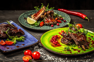 assortment of dishes with pork ribs grilled with a spicy sauce. Tasty snack served with green seedlings. concept of restaurant serving, top view. Copy space