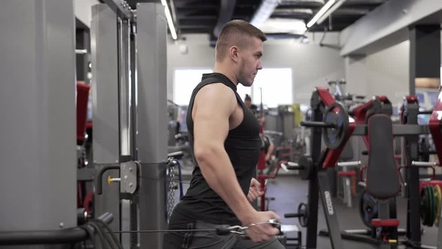 Strong Young Male Adult Doing Simulator Exercise For Chest and Shoulders Muscles