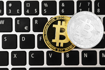Bitcoin coins cryptocurrency on the laptop keyboard.