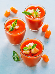 Delicious gaspacho soup in glass. Traditional spanish cold soup puree gaspacho or gazpacho on gray cement background. View from above or top view or flat lay. Vertical.
