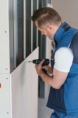 Builder installing white chip board cladding