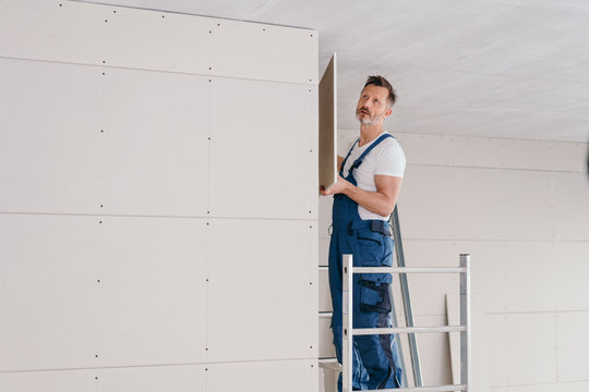 Builder Fitting Wall Cladding In A New Build House